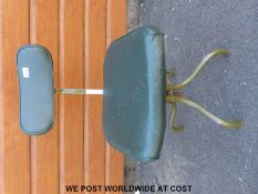 A leather swivel office or industrial chair raised on a metal base