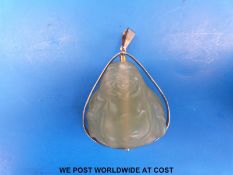 A yellow metal pendant marked 750 set with a carved Chinese Buddha