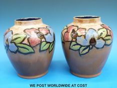 A pair of c1930 Royal Doulton vases with enamelled floral decoration (15.