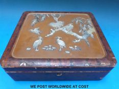 A Japanese lacquer box decorated in mother of pearl depicting herons in a tree