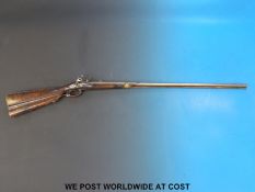 A 32 bore hammer action flintlock gun with Roman type lock, carved stock and trigger guard,