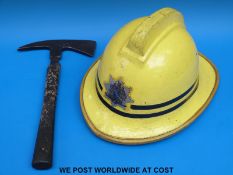A fireman's helmet dated 1986 to underside and an axe
