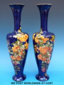 A pair of late Victorian Doulton Lambeth pottery slender oviform shouldered vases with trumpet