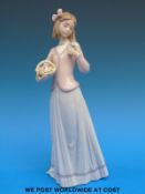 A Lladro figure of a girl with basket of flowers (25cm tall)
