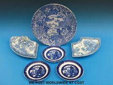 Two 19thC crescent shaped willow pattern serving dishes, one with cover,