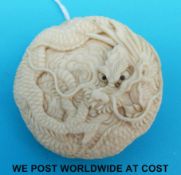 A carved ivory Japanese button of a dragon