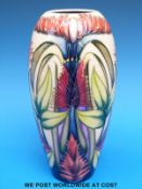 A Moorcroft tapered vase decorated with exotic flowers (19cm tall)