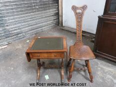 A carved chair and leather inset side table.