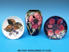 A Moorcroft pin dish decorated with an anemone and another Moorcroft pin dish decorated with