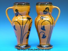 A pair of large Arts & Crafts vases with stylised foliate decoration on a mustard ground