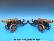A pair of brass cannons on cast iron gun carriages,