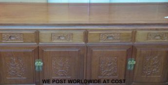 A light elm Chinese sideboard with four drawers above and books below with carved decoration and