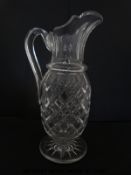 A large clear glass ewer with applied handle,