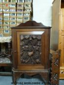 A 19thC mahogany corner cupboard on stand with heavily carved grape and vine decoration (Height