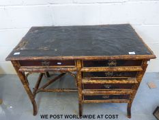 A oriental bamboo ladies desk with five drawers with decorative wooden panel to the rear and
