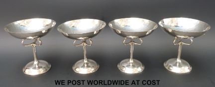 A set of four Edward VII hallmarked silver Arts and Crafts / Art Nouveau pedestal sweet meat or bon