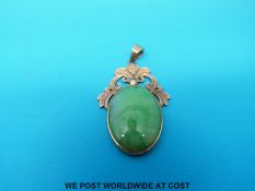 A 14ct gold pendant set with an oval jadeite cabochon