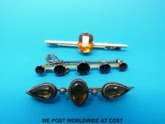 Three yellow metal brooches, one marked 15ct set with a citrine, one 9ct set with citrine,