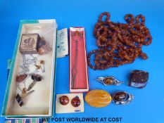 A collection of amber and amberite jewellery including brooches,