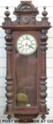 A Vienna style wall clock with columned decoration, ivory coloured dial, pierced hands,