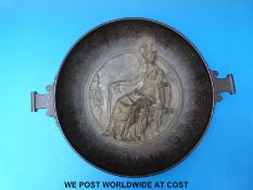 A German spelter and cast pedestal bowl with a classical figure in relief to the bowl,