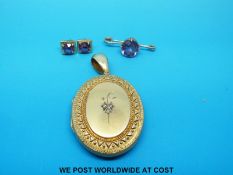 A Victorian yellow metal locket set with three old cut diamonds to one side,
