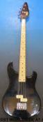A cased Vox bass guitar in black lacquered finish,