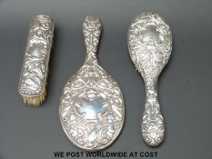 An embossed hallmarked silver dressing table set comprising mirror,