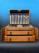 A silver plated Art Deco 12 place setting canteen of cutlery in light oak Wellington chest type