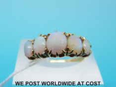 A yellow metal and rubies ring set with five graduated opals marked 18ct,