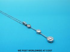 A platinum pendant set with three round cut diamonds, the largest approximately 0.