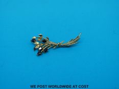A 9ct gold brooch set with sapphires in the form of a bunch of flowers (3g all in)