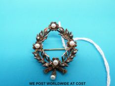 A yellow metal brooch set with diamonds and pearls
