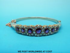 An Art Deco bangle/ bracelet set with seven round cut rubies surrounded by diamonds (largest ruby