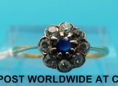 A yellow metal ring marked 18ct set with a sapphire to the centre surrounded by diamonds (size O)
