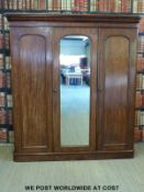 A 19thC mahogany compactum linen press with three doors including a central mirrored example.