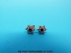 A pair of 9ct gold earrings set with diamonds and rubies in a cluster