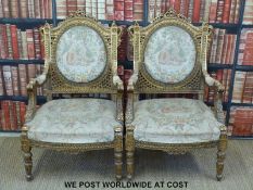 A pair of pierced and carved gilt wood French upholstered armchairs