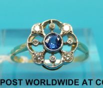 A yellow metal ring marked 18ct set with a sapphire surrounded by diamonds (size N)