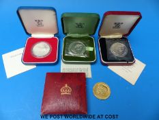 Three cased silver proof crowns and a 1902 Coronation medal, possibly silver gilt,