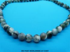 A necklace made up of spherical moss agate beads