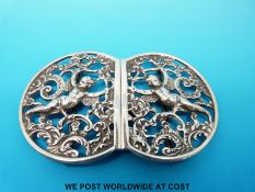 A hallmarked silver nurse's belt buckle with cherub decoration