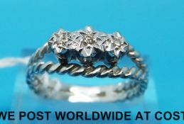 A 9ct white gold ring set with three diamonds in an illusion setting
