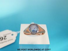 A yellow metal ring set with a cushion cut sapphire (size Q)