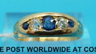 An Edwardian yellow metal ring marked 18ct set with alternating old cut diamonds and sapphires