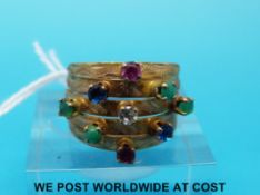 A yellow metal ring set with various coloured stones (size J/K)