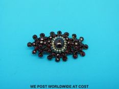 A Victorian yellow metal brooch set with Bohemian garnet and seed pearls