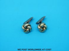 A pair of silver cufflinks in the form of knots