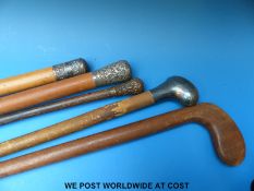 A collection of walking sticks including white metal topped examples (one marked Sterling) and a