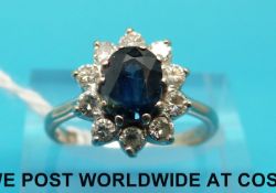 An 18ct white gold ring set with an oval sapphire surrounded by diamonds (size N)